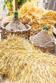 Autumn harvest demijohn wicker with bales of hay