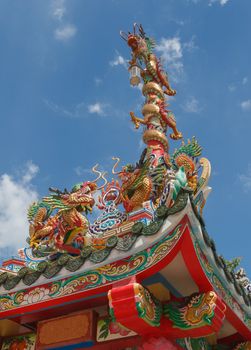 Symbolic of Chinese shrine is golden dragon. In general, two golden dragon are on the rooftop and another is on the top of the red pillar with the sacred lantern. The photo is taken at Chinese shrine in Bangkok, Thailand.