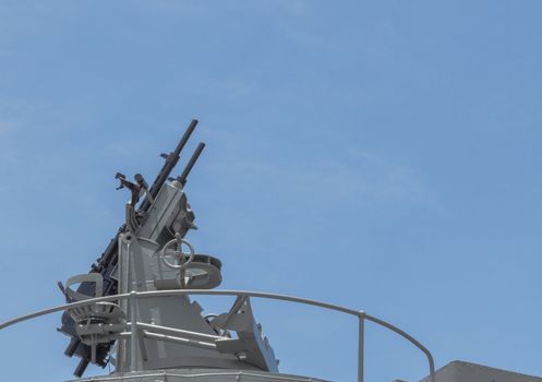 Machine gun on the deck of battleship with the blue sky background