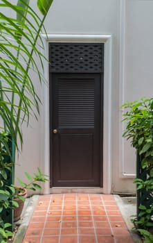 Doorway with green leaves leads to the white buiding.