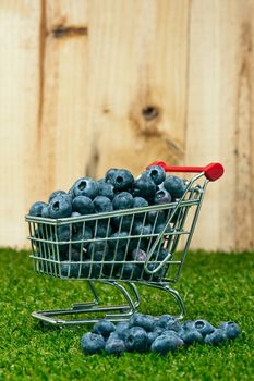 Blueberries in a shopping cart in front of a timber wall