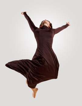 Girl dancing in a dark dress with a gray background. isolate