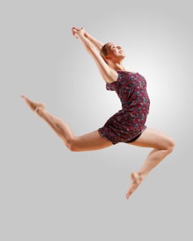 Girl dancing in a color dress with a gray background. isolate