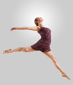 Girl dancing in a color dress with a gray background. isolate