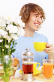 Young happy man drinking tea at home