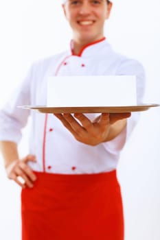 Male cook in uniform holding an empty tray