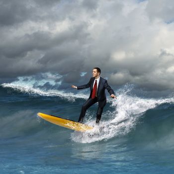 Image of young business person surfing on the waves of the ocean