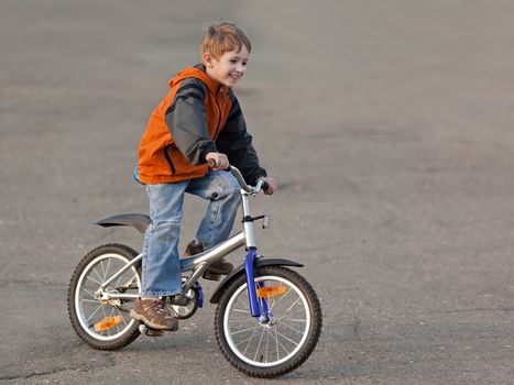 Little smiling child boy cycling sport bicycle outdoor