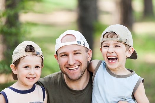 Smiling father and little sons - family happiness