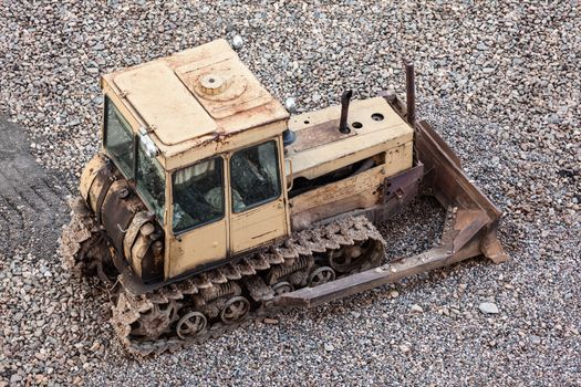 Old rusty earth digging caterpillar bulldozer machine working at building construction site