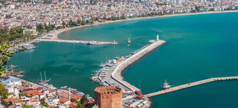 Summer vacations - blue Mediterranean sea and Turkey Alanya east coast beach resort with lighthouse and ship bay view from ancient mountain castle wall