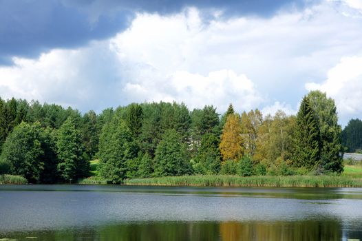 Lake and trees on a background of the blue sky