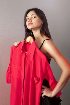 close up of girl which tries on red shirt in shop