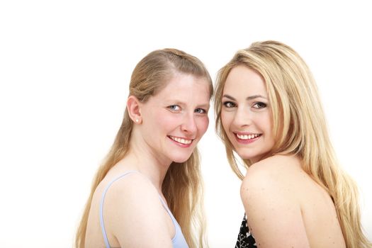 Head and shoulders studio portrait of two cheerful smiling outgoing women standing close together facing each other 