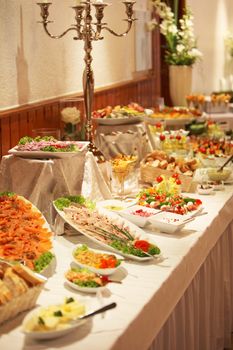 Cold buffet display with an assortment of salads, vegetables, meat and dessert at a catered event such as a wedding Cold buffet display with an assortment of salads, vegeatbles, meat and dessert at a catered event such as a wedding 