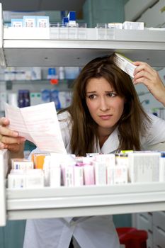 Woman working in pharmacy looking prescription worried