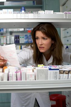 Beautiful woman pharmacist looking for medicine worried