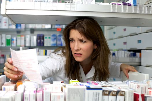 Beautiful woman working in pharmacy with prescription and medicine