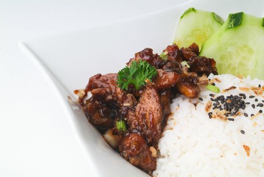 Chicken with rice and vegetables in background