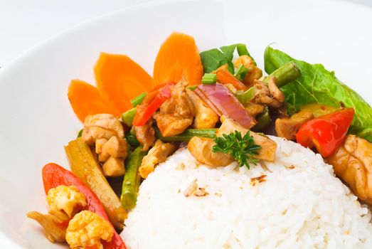 Chicken with rice and vegetables in background