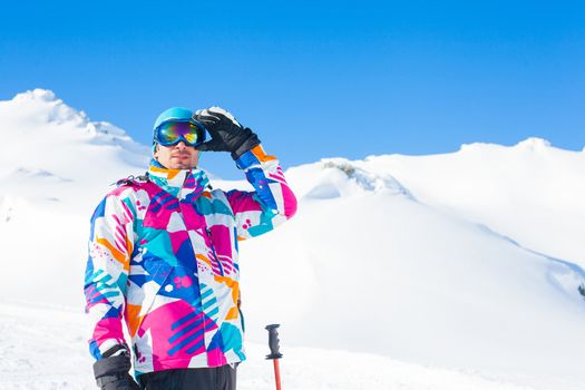 Young man with skis and a ski outfit in the Zillertal Arena, Austria