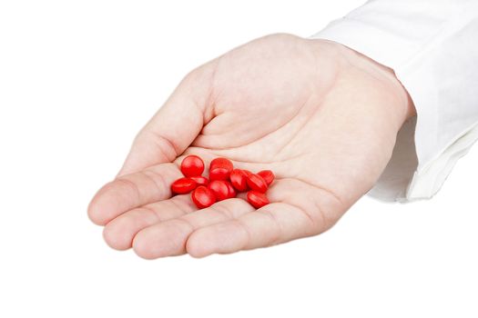 Close-up photograph of a hand holding red tablets.