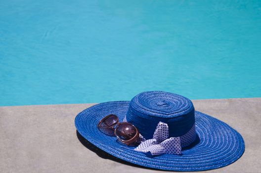 Women's summer heat and sunglasses by the swimming pool