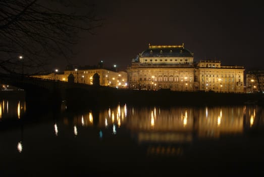 The Czech National Theater in Prague is reflecting after the dusk in the river Vltava