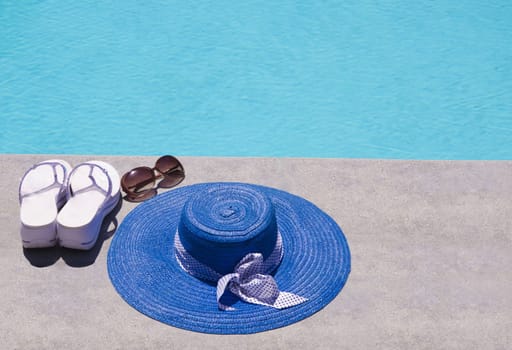 Women's summer heat, flip flops and sunglasses by the swimming pool
