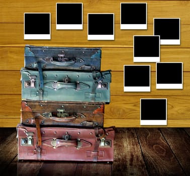Retro travel concept, Old travel bags with photo frames post on wooden wall