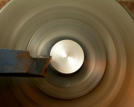 Turning lathe in action is processing metal bar - with motion blur