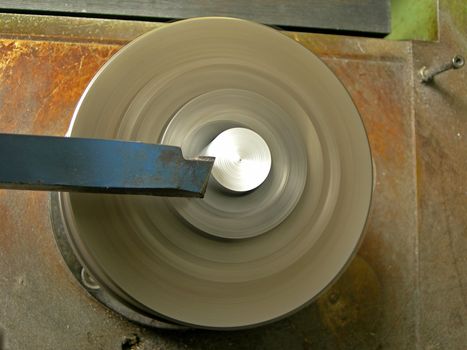  Turning lathe in action is processing metal bar - with motion blur        