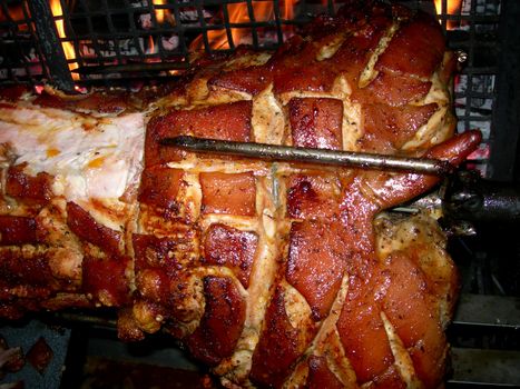           Barbecue with young pig on a grill with wooden coal 