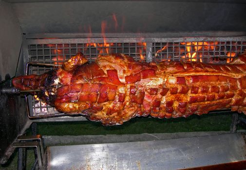            Barbecue with young pig on a grill with wooden coal 