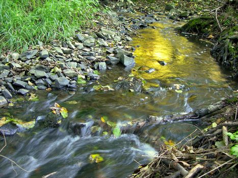 Beautiful sunrise mirroring in a brook with long exposure 