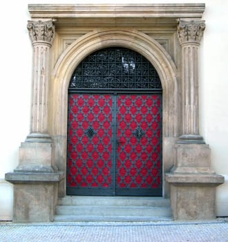 Old metal portal of a church in Prague with two pillars on a side