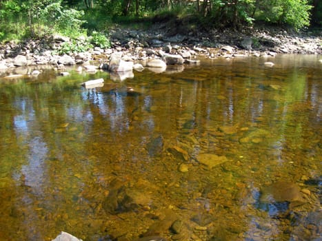           Surface of limpid mountain river and its bank