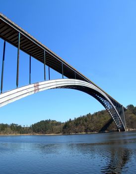 Bridge over the Vltava river. Massive steel construction with a long arch.