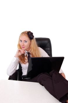 Businesswoman with computer relaxing at the desk, legs up, isolated on white