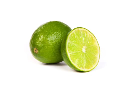 One whole lime and one half lime isolated on a white background