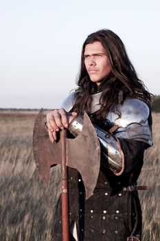 Medieval knight in the field with an axe