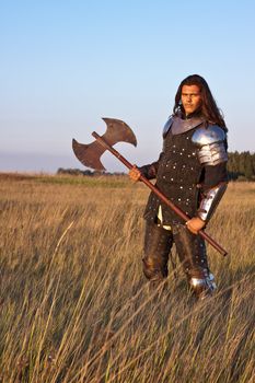 Medieval knight in the field with an axe