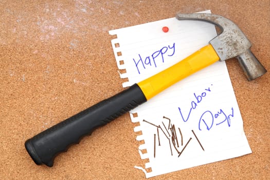 hammer and rusty nails with paper attach to cork board for labor day
