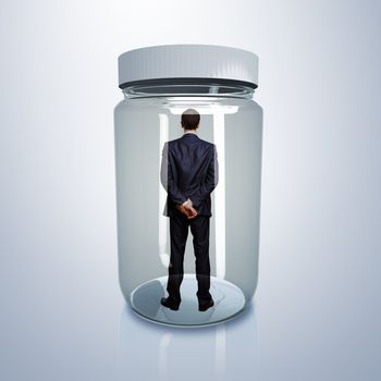 Businessman trapped inside a transparent glass jar