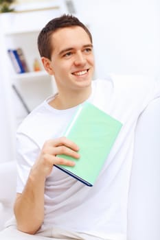 Young handsome man at home with a book