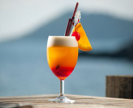 Juicy cocktail on wooden table by the sea can make you refresh in hot day