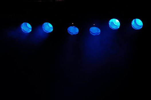 Lights and smoke. Row of blue spotlights from a stage.