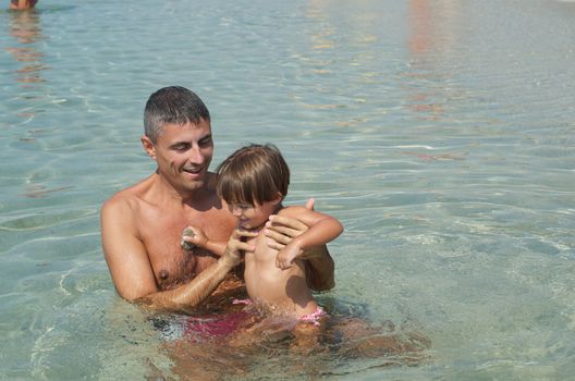 Father and Son smiling at the beach with sea background