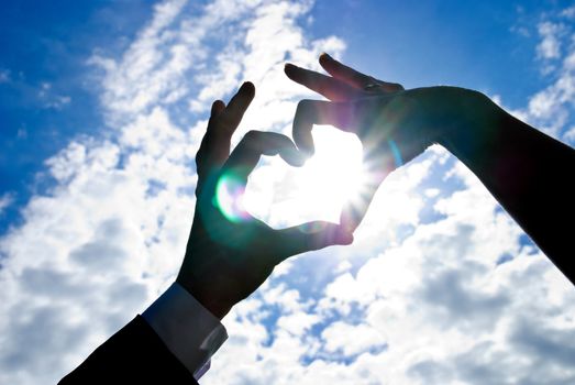 Two hands of newlywed looks like heart with sun inside