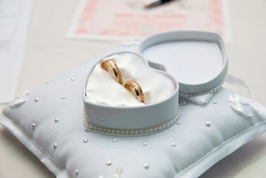 Two wedding rings in a heart-shaped box